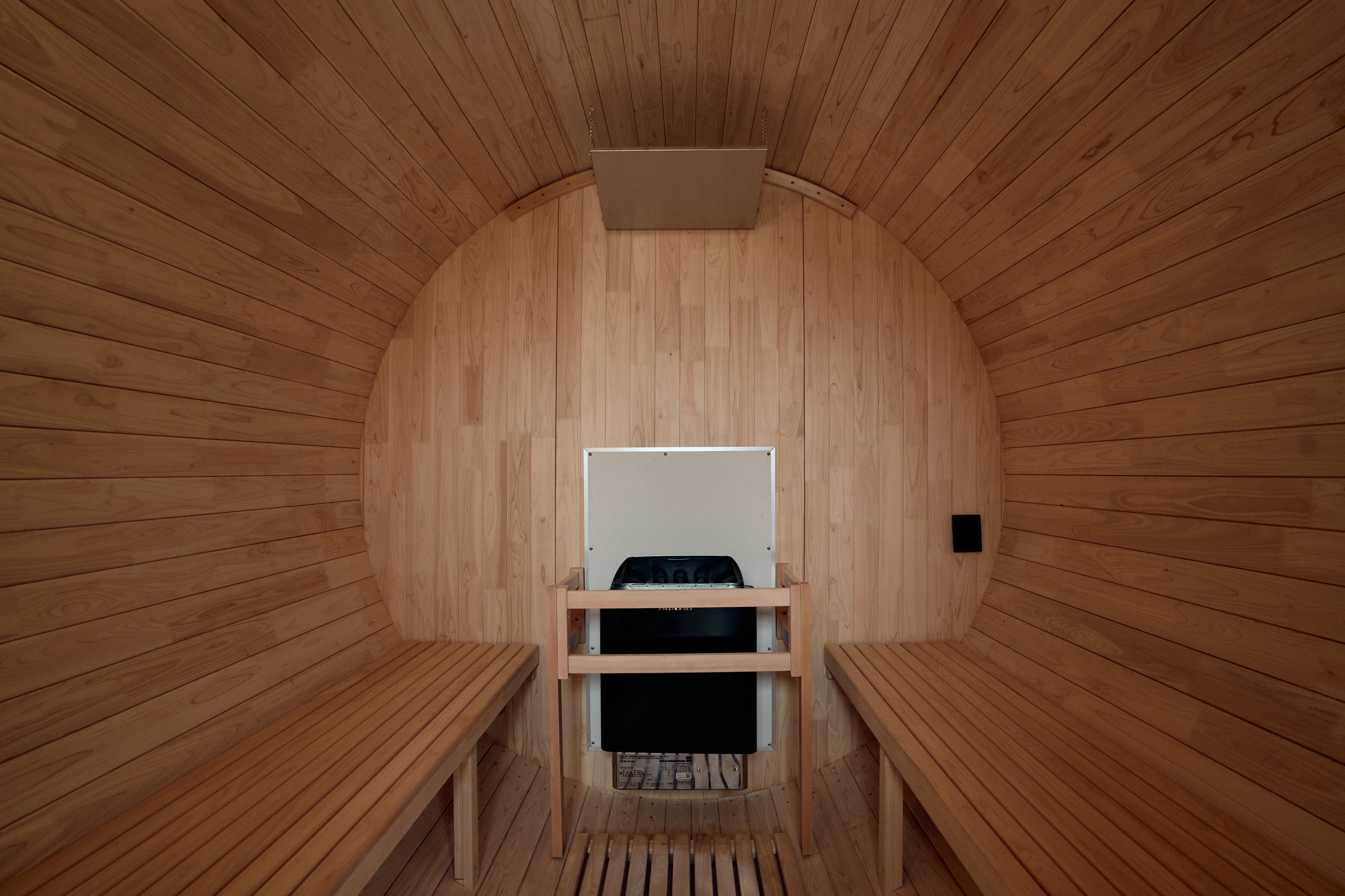 Inside the cedar barrel sauna, with the heater